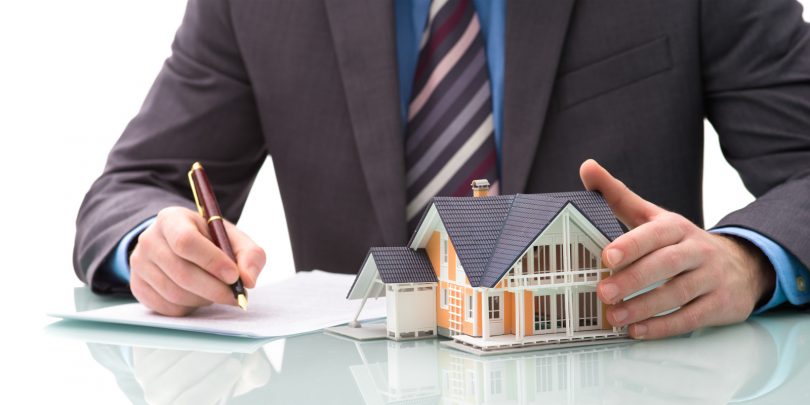 homme d'affaires avec une maison assurance emprunteur